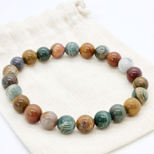 Multicolored ocean Jasper beaded bracelet on a white fabric background