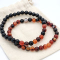 Two beaded bracelets on a white fabric background