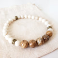 Creations 4 Wildlife bracelet with white and brown beads on a beige fabric background